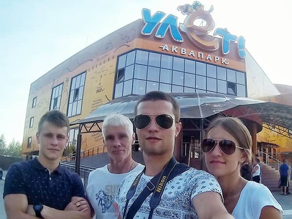 люди фотографируются напротив аквапарка